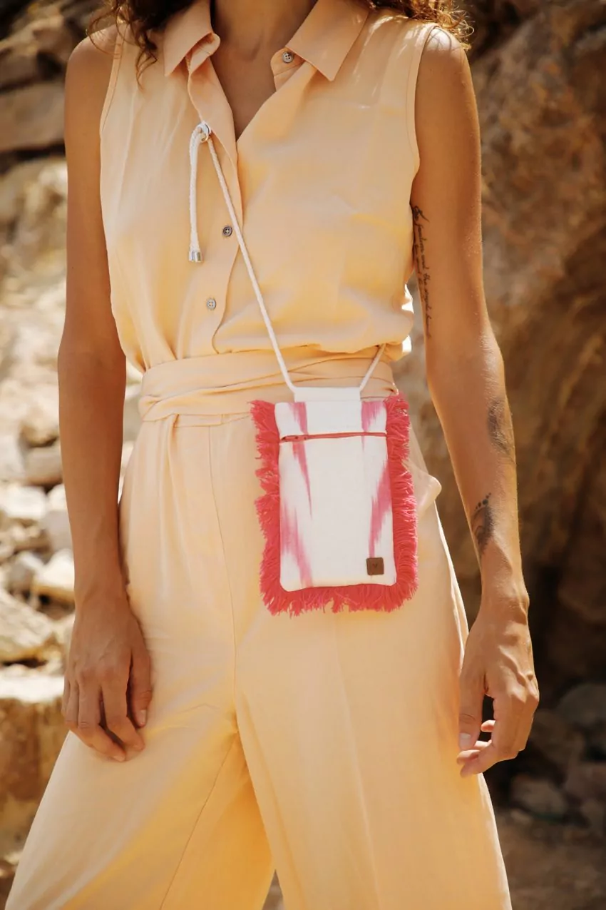 Modelo luciendo bolso artesanal de Teixits Vicens en ambiente natural
