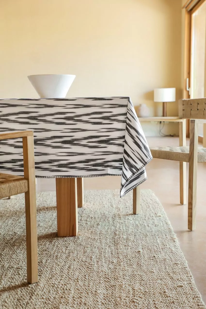 mantel artesanal con greca ikat negra estilo mallorquín sobre fondo blanco